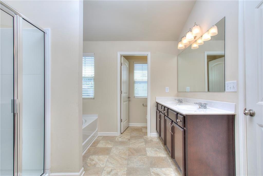 565 Dasheill Lane Atlanta, GA 30349 - Photo 6 of 11 a bathroom with a sink a mirror and a bathtub