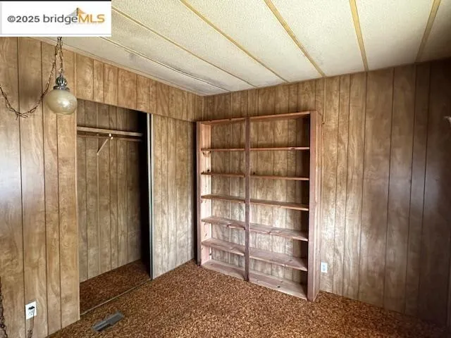 a view of empty room with wooden floor and cabinet