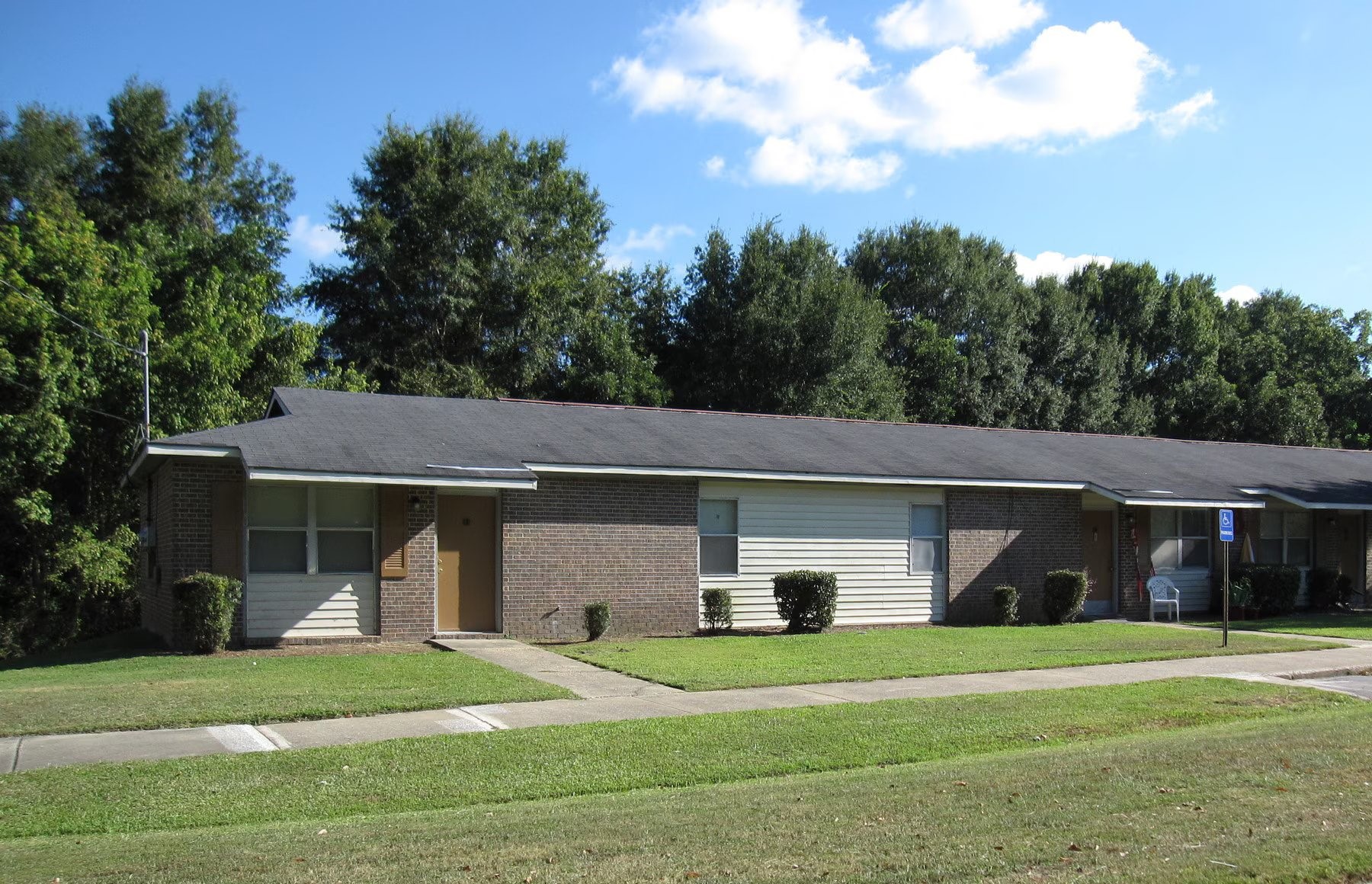 a front view of a house with a yard and trees