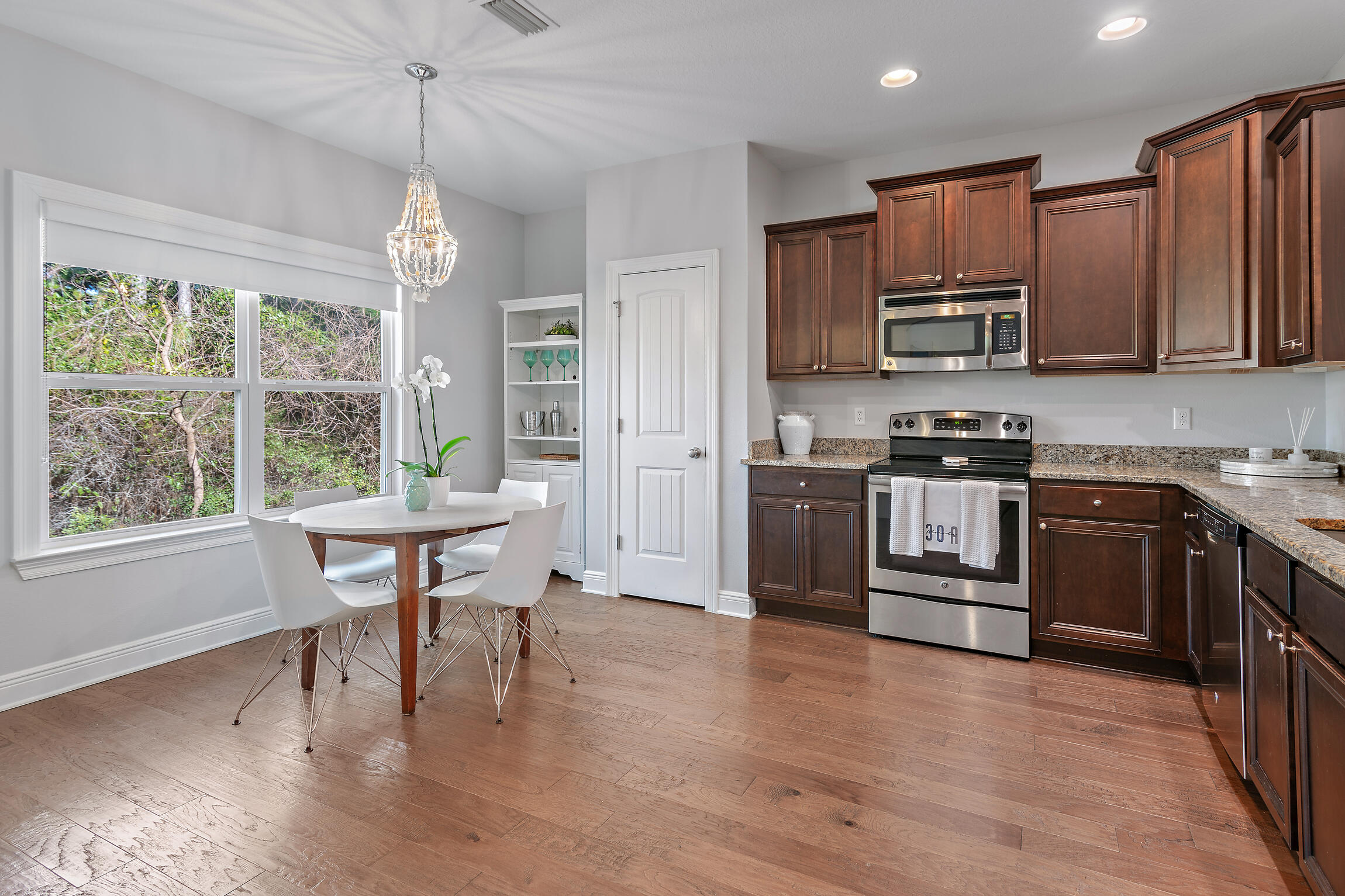 90 Ocean Spray Circle Santa Rosa Beach, FL 32459 - Photo 8 of 57 a kitchen with stainless steel appliances granite countertop a stove top oven a sink dishwasher a dining table and chairs with wooden floor