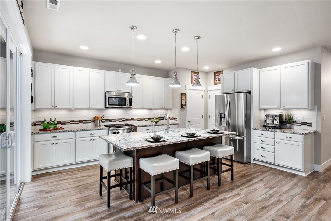 3615 177th Street Southeast Bothell, WA 98012 - Photo 5 of 32 a kitchen with kitchen island granite countertop a sink and stainless steel appliances
