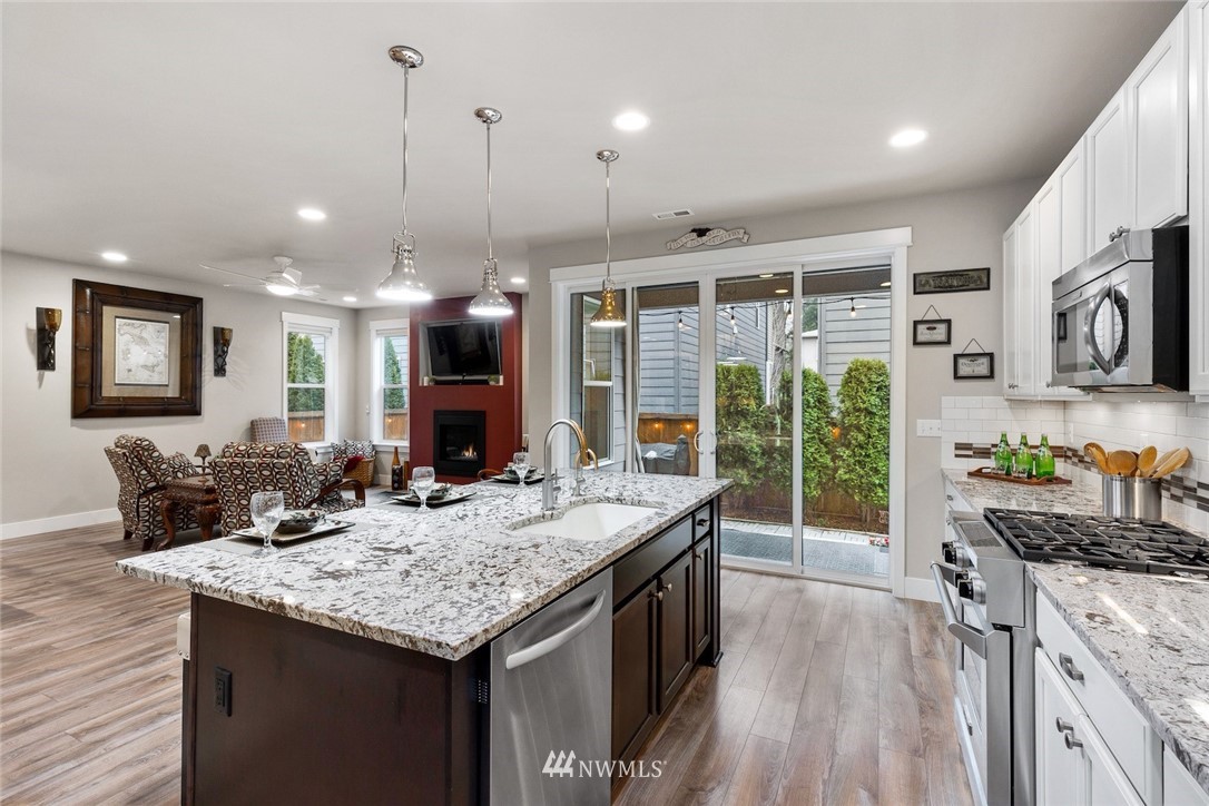 3615 177th Street Southeast Bothell, WA 98012 - Photo 6 of 32 a kitchen with kitchen island granite countertop a stove and a wooden floors