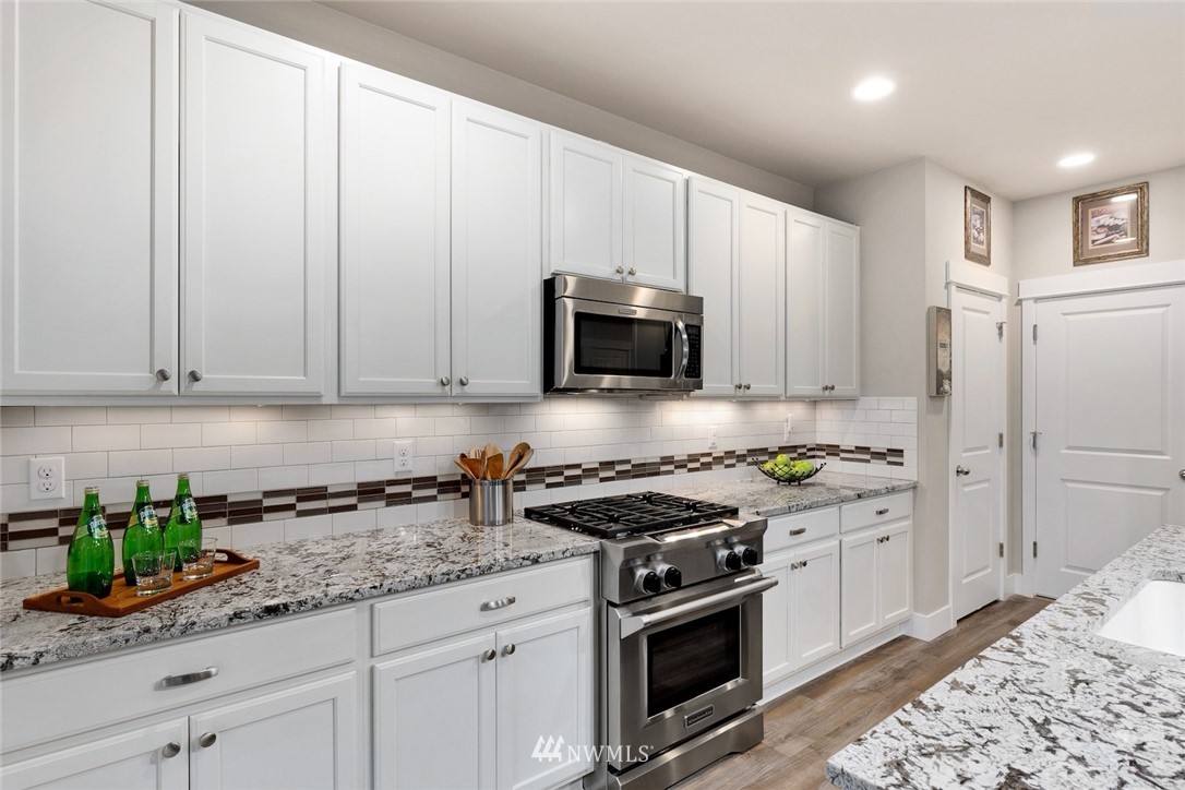 3615 177th Street Southeast Bothell, WA 98012 - Photo 7 of 32 a kitchen with stainless steel appliances granite countertop white cabinets and a stove
