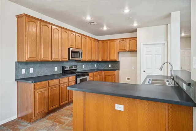 a kitchen with stainless steel appliances granite countertop a sink stove and refrigerator