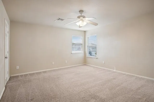 a view of an empty room with a chandelier fan