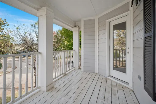 a view of a porch with wooden floor and floor to ceiling window