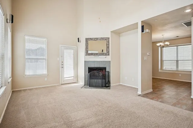 an empty room with windows and fireplace