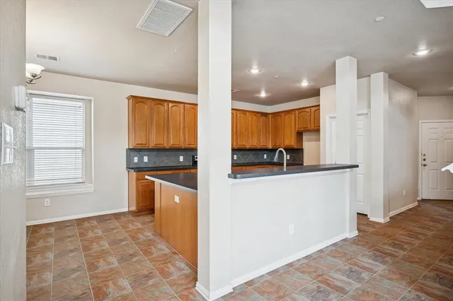 a kitchen with stainless steel appliances granite countertop a refrigerator and a stove top oven