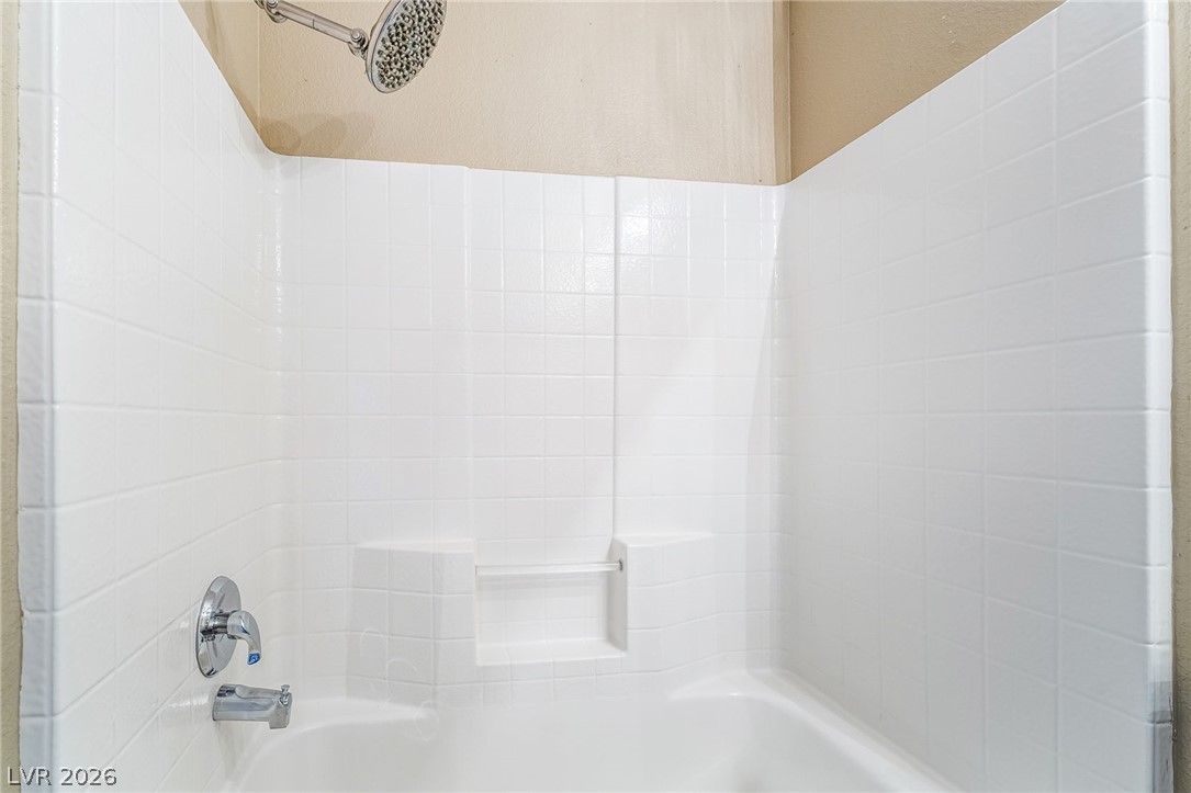 224 Positive Point Street Henderson, NV 89012 - Photo 32 of 44 Crisp white tiling surrounds this classic bathtub shower combination featuring built-in shelving.