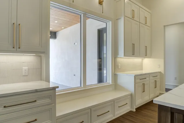 a hallway with white cabinets and wooden floor