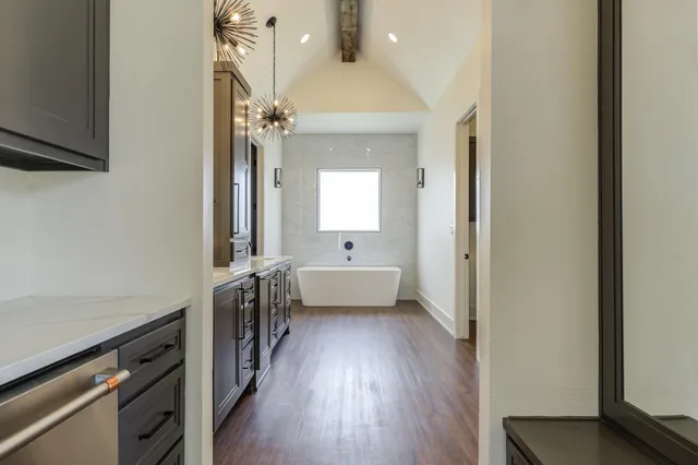 an empty room with wooden floor chandelier fan and windows