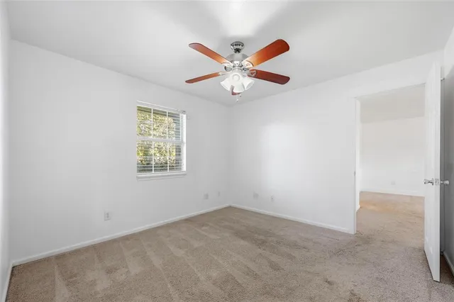 an empty room with a window and a fan