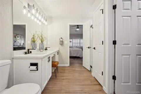 a bathroom with a sink a toilet a mirror and shower