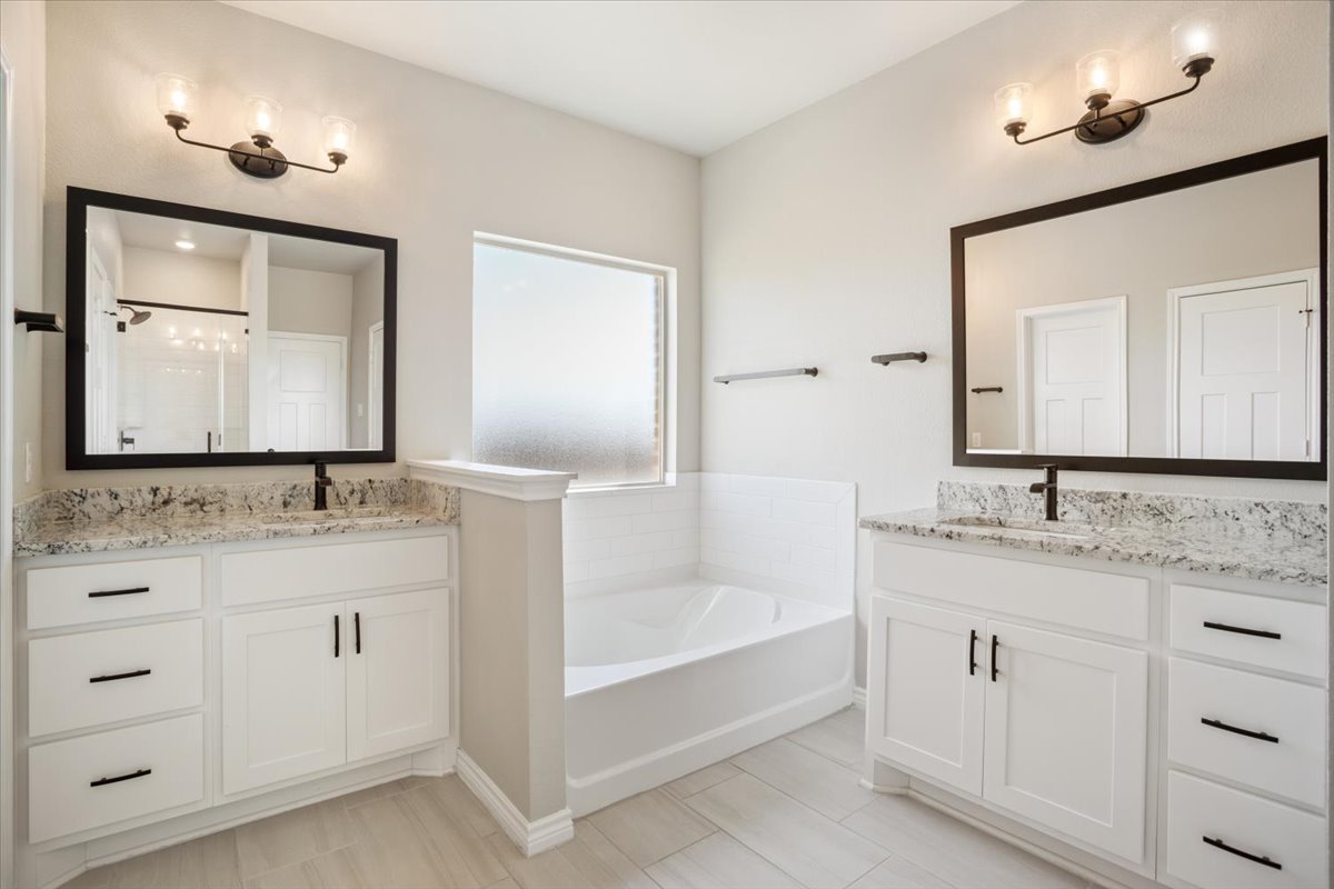 1701 Meadow Crest Salado, TX 76571 - Photo 17 of 30 a bathroom with a double vanity sink and mirror with bathtub