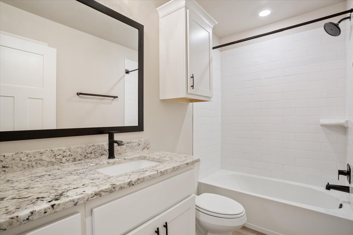 1701 Meadow Crest Salado, TX 76571 - Photo 26 of 30 a bathroom with a granite countertop sink toilet and a mirror