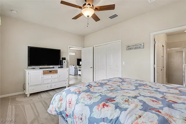 a bedroom with a bed flat screen tv and a chandelier