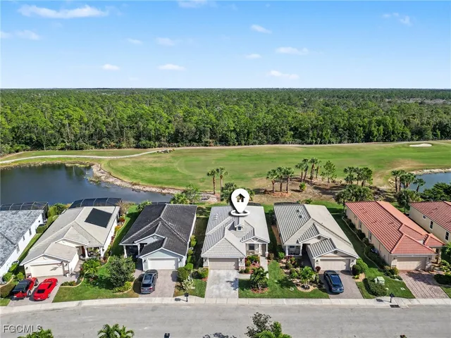 an aerial view of residential houses with outdoor space and lake view