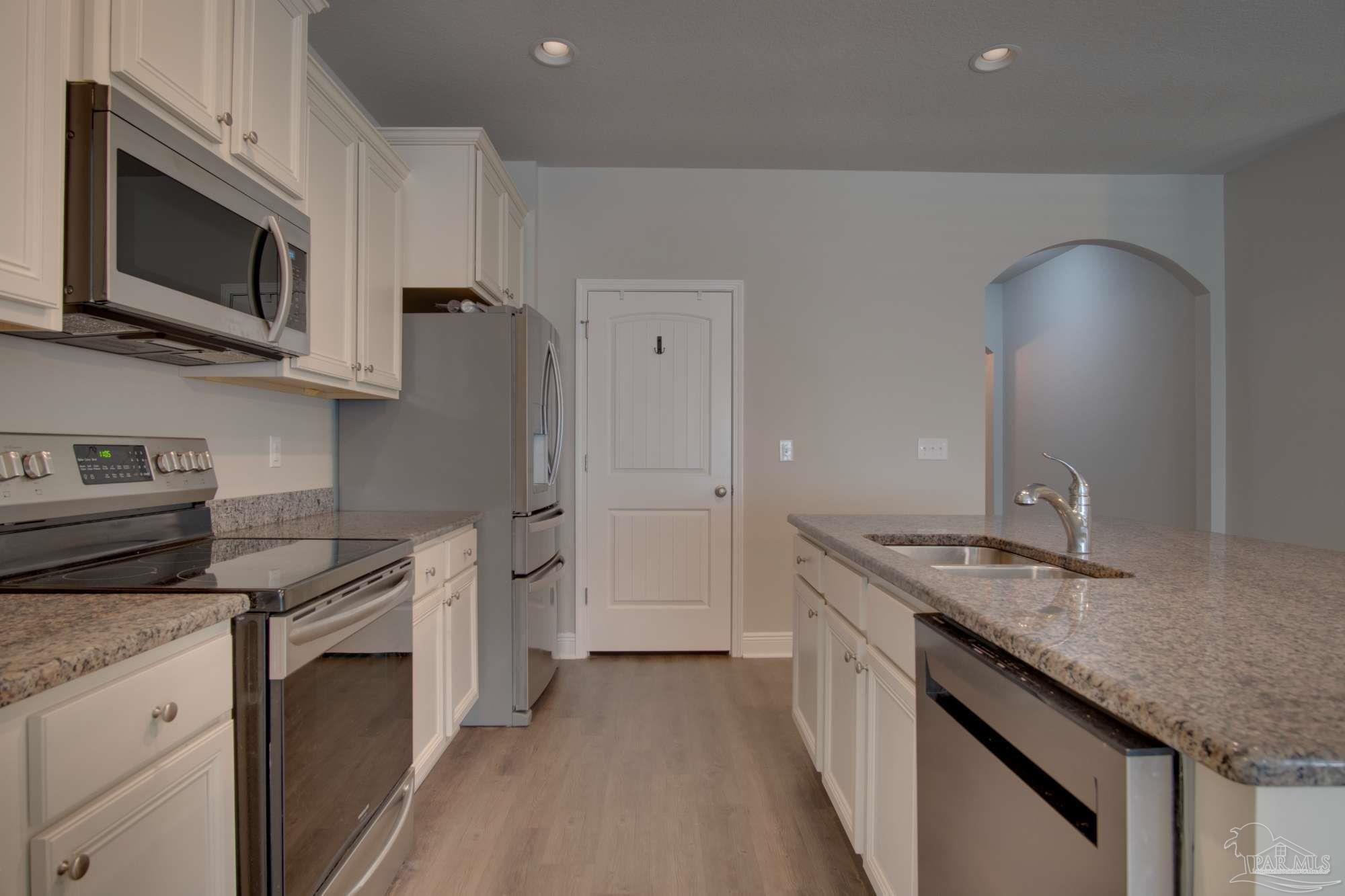 6239 Ladera Trail Pace, FL 32571 - Photo 12 of 27 a kitchen with stainless steel appliances granite countertop a sink stove and refrigerator