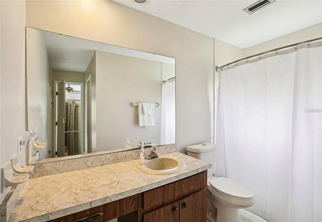 19254 Blount Road Lutz, FL 33558 - Photo 21 of 34 a bathroom with a granite countertop sink a toilet and a mirror