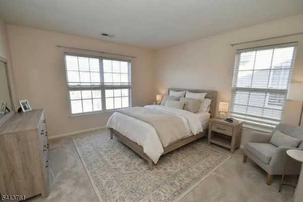 a bedroom with a bed couch and a large window