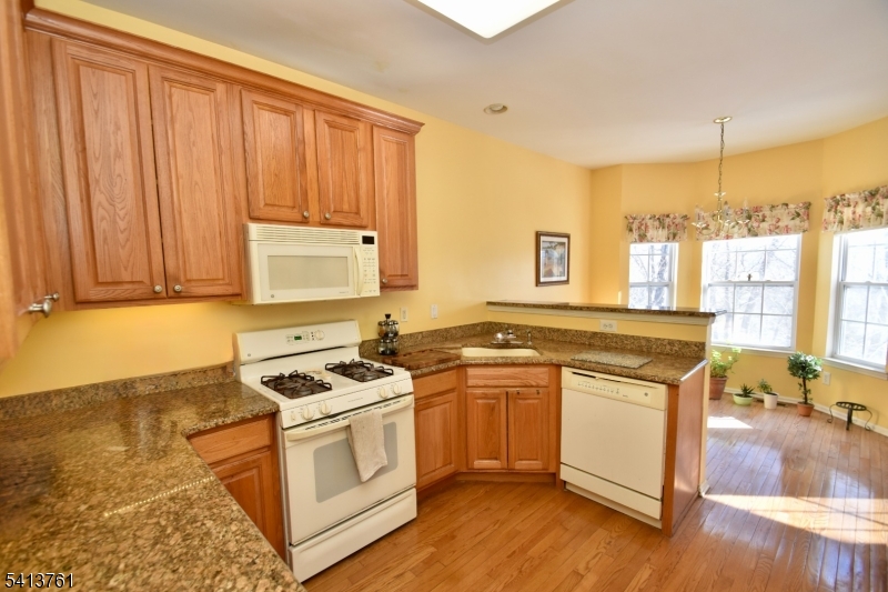 263 Ridge Drive Pompton Lakes, NJ 07442 - Photo 6 of 20 a kitchen with stainless steel appliances granite countertop a stove a sink dishwasher and a refrigerator with wooden floor