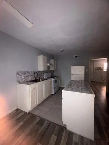 a kitchen with a sink a stove and cabinets