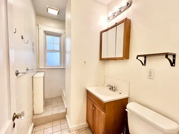 a bathroom with a toilet sink and mirror