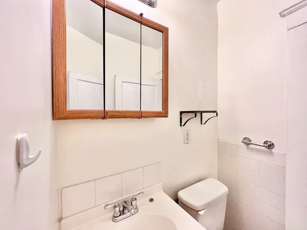 a bathroom with a toilet sink and mirror