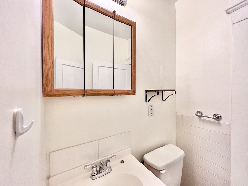 26 Chiswick Road, Unit 6 Boston, MA 02135 - Photo 13 of 31 a bathroom with a toilet sink and mirror