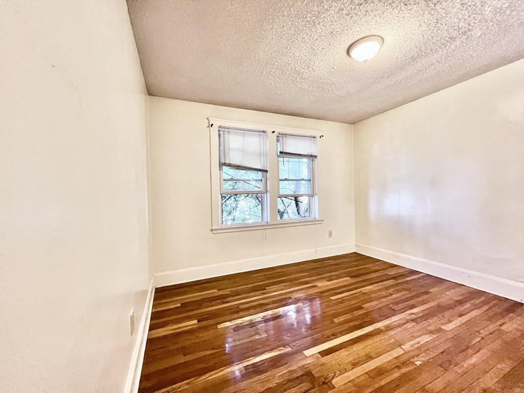 26 Chiswick Road, Unit 6 Boston, MA 02135 - Photo 14 of 31 a view of empty room with window and wooden floor