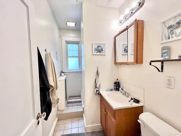 a bathroom with a sink toilet and a mirror