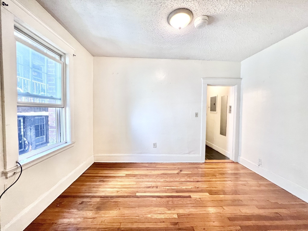 26 Chiswick Road, Unit 6 Boston, MA 02135 - Photo 9 of 31 a view of an empty room with wooden floor and a window