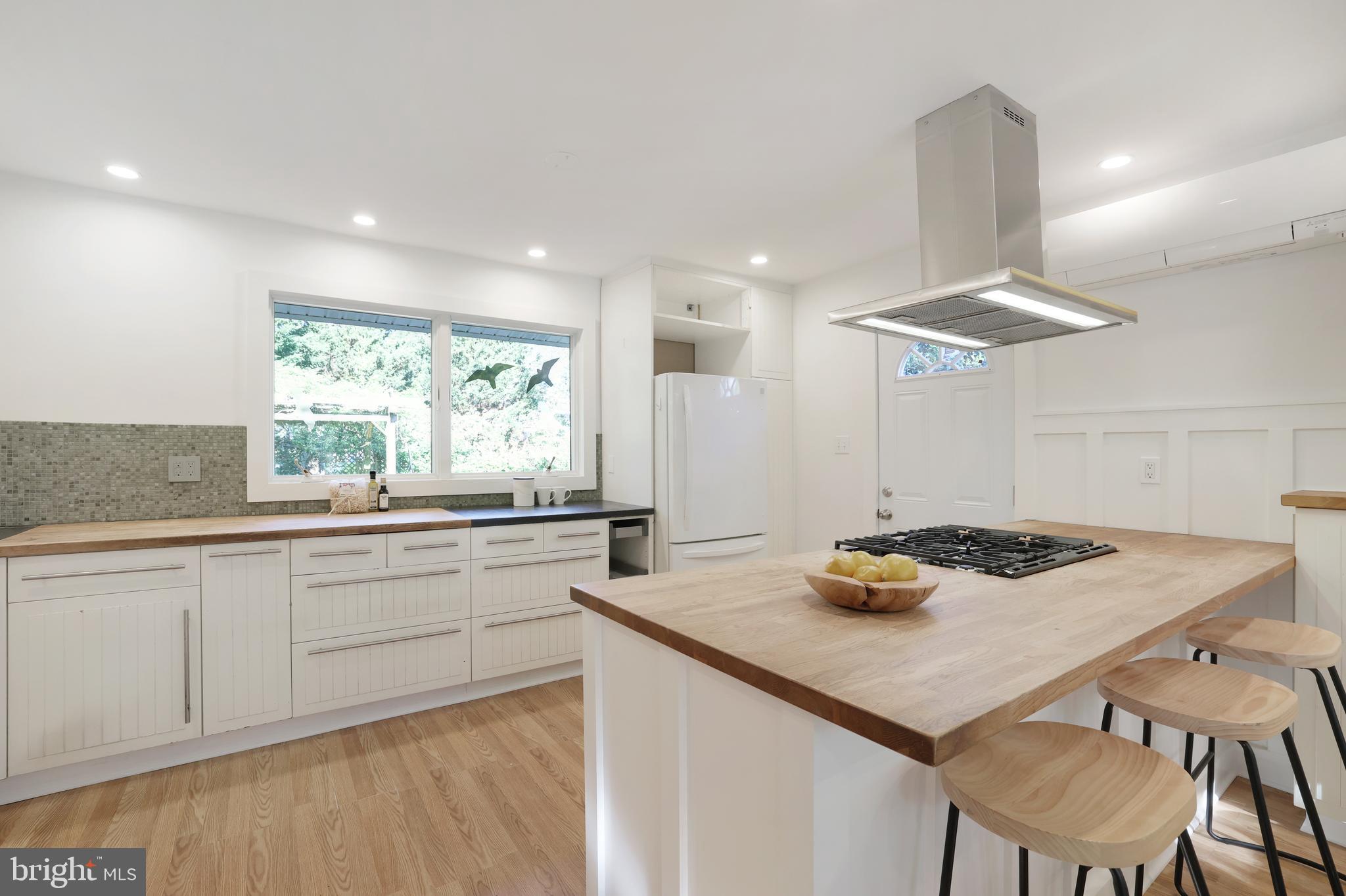11812 Selfridge Road Silver Spring, MD 20906 - Photo 14 of 42 a kitchen with kitchen island a stove a table and chairs in it