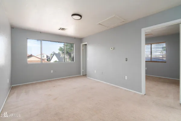 an empty room with windows and mirror