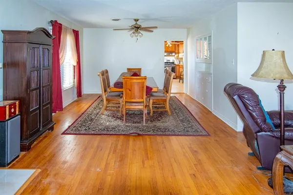 a dining room with wooden floor furniture and a window