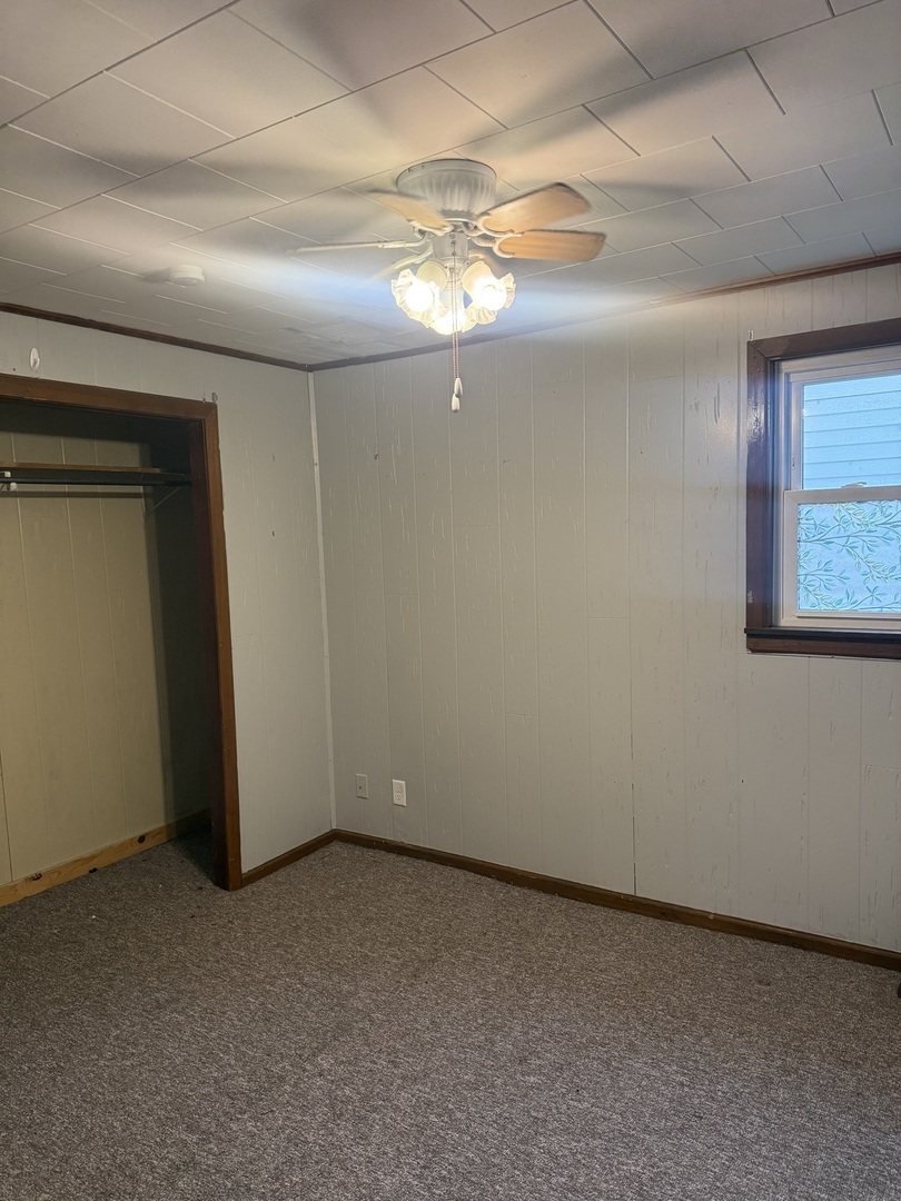 312 East 11th Street Georgetown, IL 61846 - Photo 11 of 25 an empty room with a chandelier fan and windows