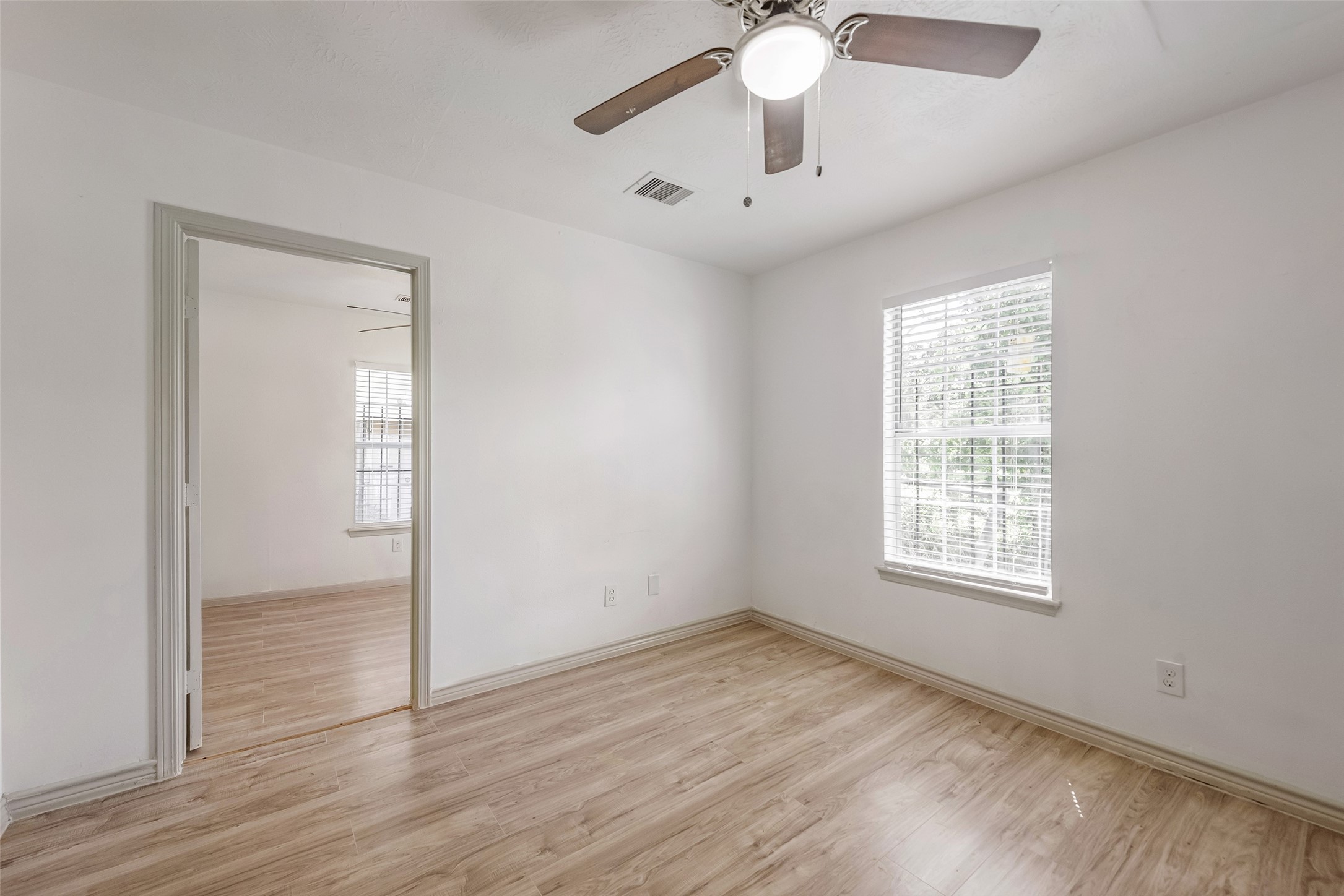6402 West Montgomery Road, Unit A Houston, TX 77091 - Photo 15 of 23 an empty room with wooden floor fan and windows