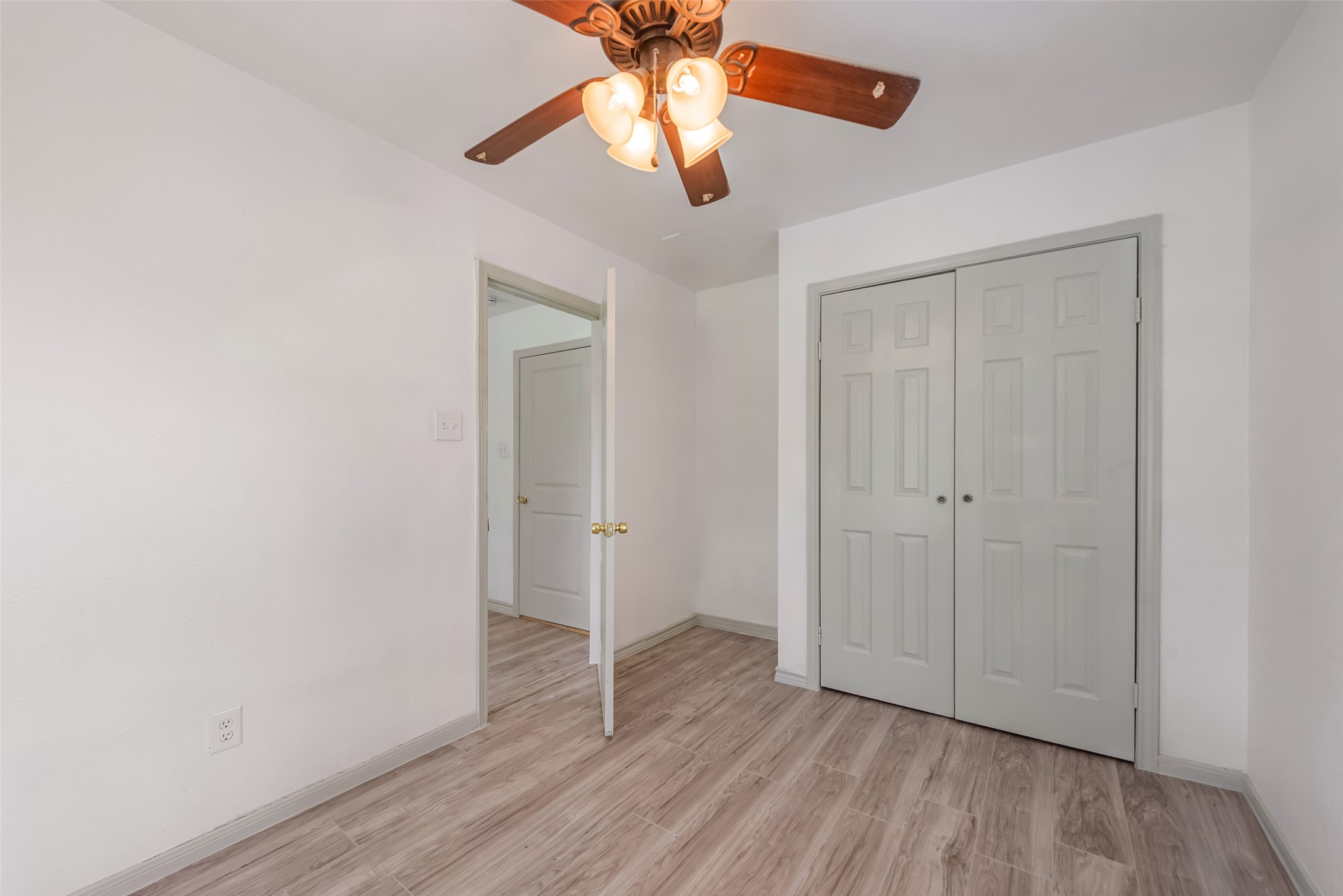 6402 West Montgomery Road, Unit A Houston, TX 77091 - Photo 17 of 23 an empty room with wooden floor hallway and a chandelier fan