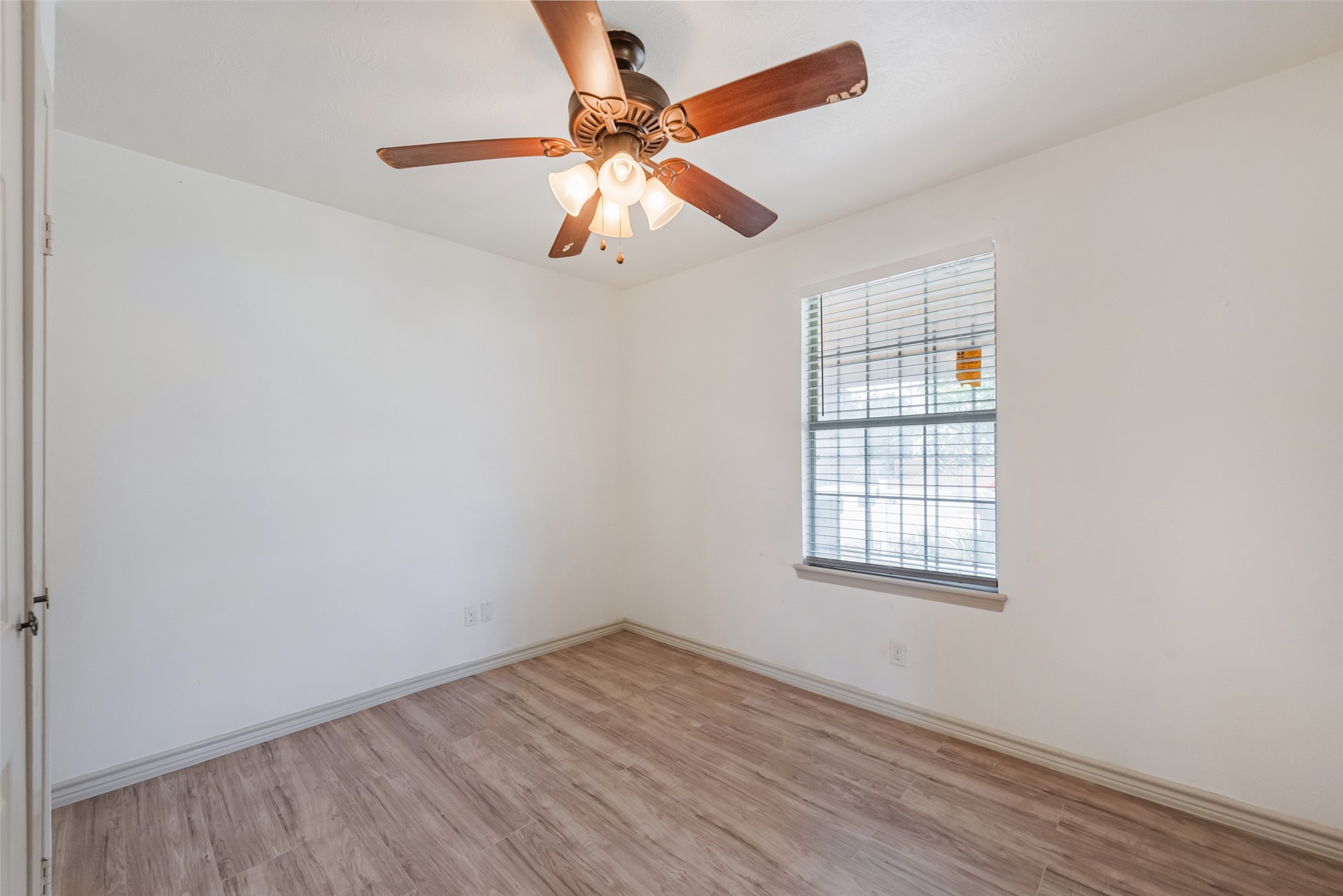 6402 West Montgomery Road, Unit A Houston, TX 77091 - Photo 19 of 23 an empty room with wooden floor fan and windows