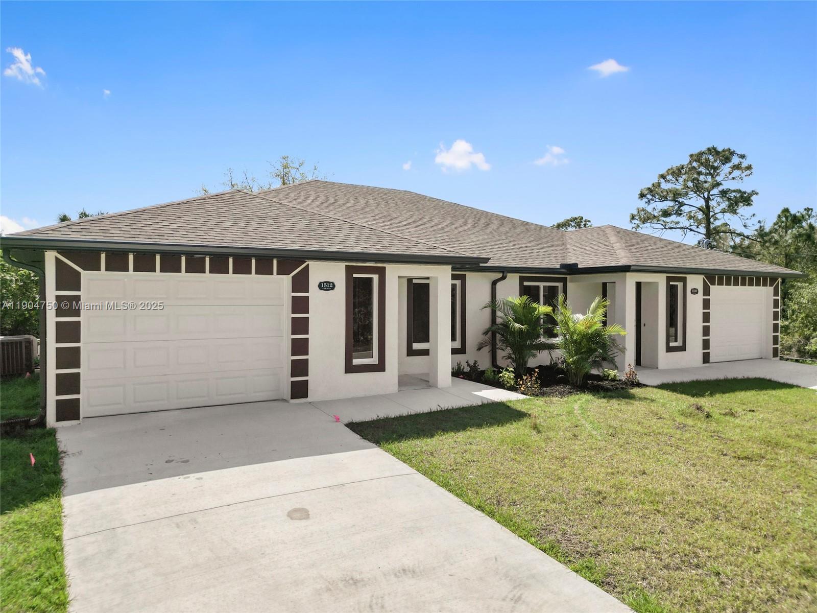 936-938 Countess Avenue Lehigh Acres, FL 33974 - Photo 15 of 24 a front view of a house with a garden and yard