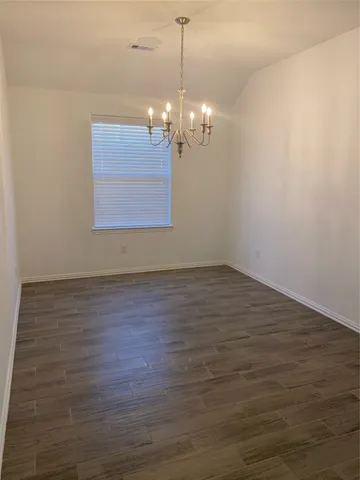 a view of a room with wooden floor and chandelier