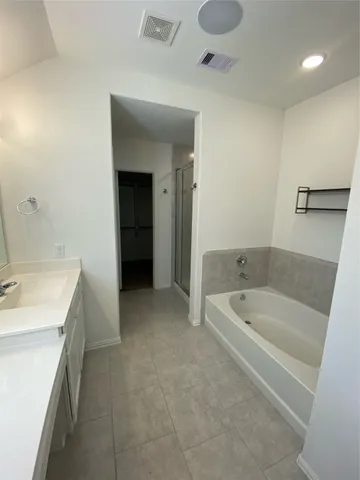 a bathroom with a tub sink and mirror