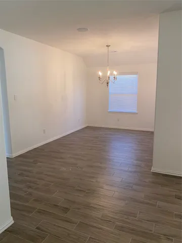 an empty room with wooden floor and cabinet
