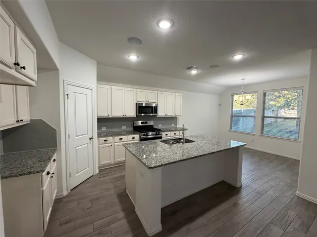 a kitchen with granite countertop a stove a sink and a granite counter tops