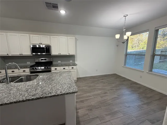 a view of an empty room with a ceiling fan and window