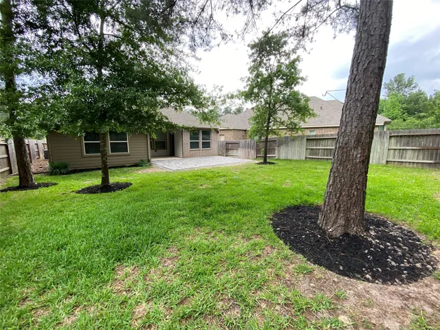 a view of a house with a yard and tree s