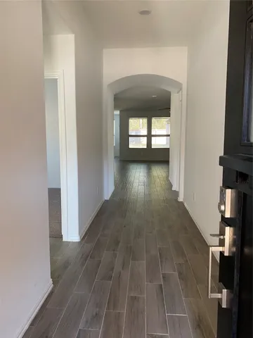 a view of a hallway with wooden floor and stairs