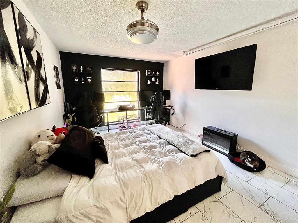 8301 Sands Point Boulevard, Unit 306S Tamarac, FL 33321 - Photo 2 of 10 a bedroom with a bed window and television