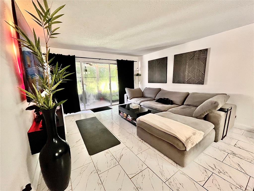 8301 Sands Point Boulevard, Unit 306S Tamarac, FL 33321 - Photo 5 of 10 a living room with furniture and a potted plant