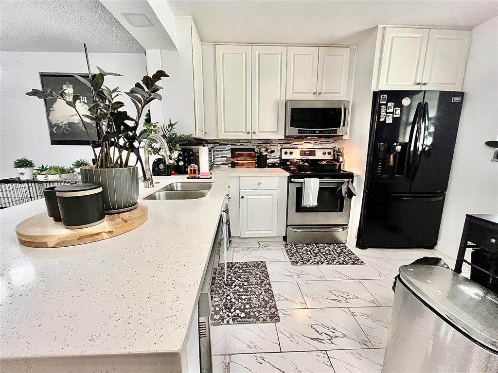 8301 Sands Point Boulevard, Unit 306S Tamarac, FL 33321 - Photo 6 of 10 a kitchen with a appliances and cabinets